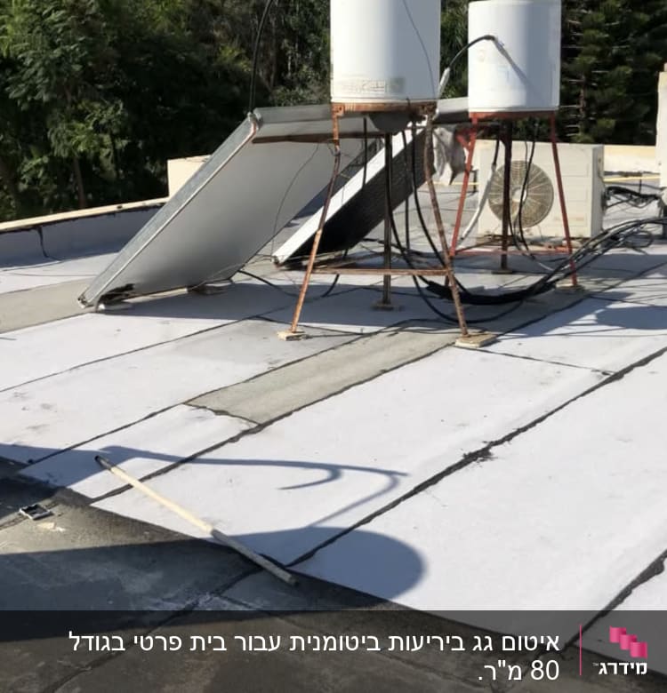 גג עם יריעות איטום לבנות ומיכלי מים